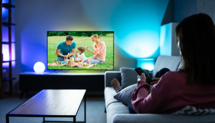 Woman watching TV with a bright screen