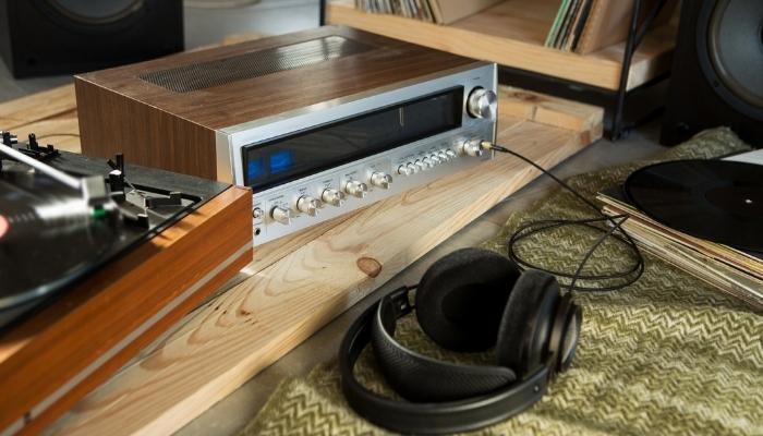 Headphones connected to big amplifier next to turntable