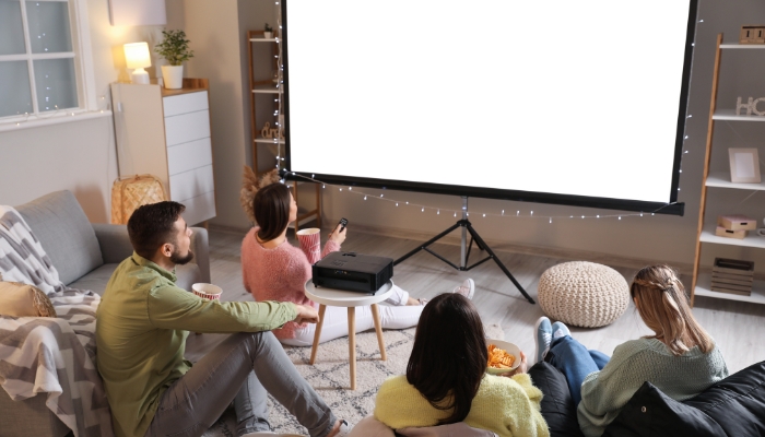Family gathered around projector screen to watch
