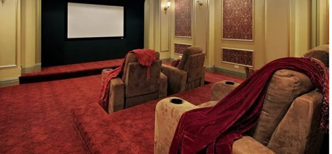 A red and gold home theater setup with tiered seating