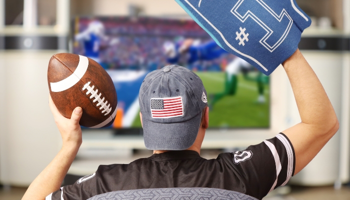 Man watching football on a large, clear TV with extra settings