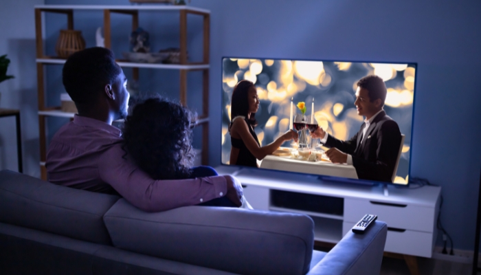 Happy couple streaming a movie in their living room