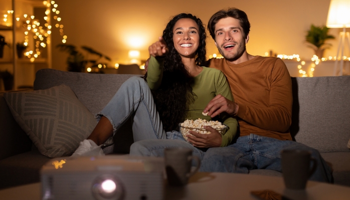A couple having a movie night together watching stuff on their portable projector