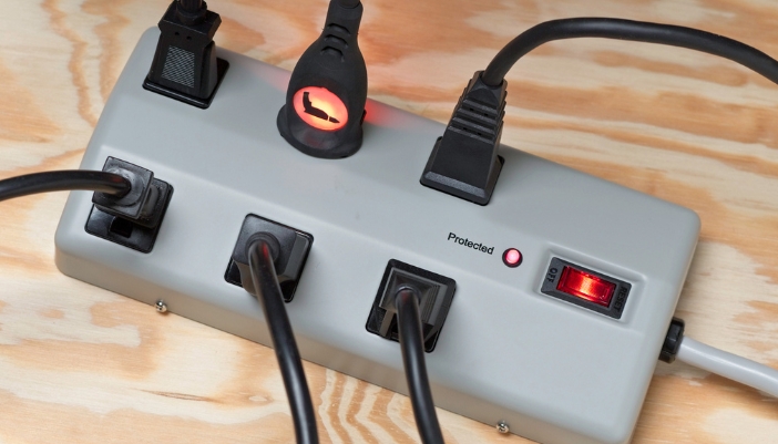 Closeup of a surge protector with lots of electronics plugged in