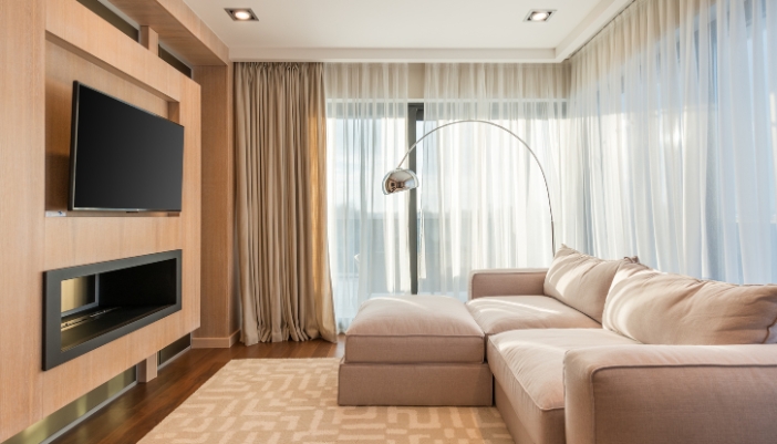 A modern living room with a wall-mounted TV with plenty of ventilation 