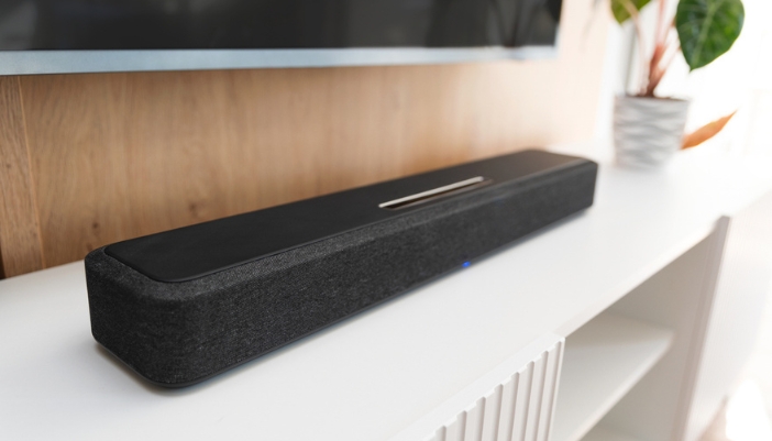 A close-up of a black soundbar on a white entertainment center.
