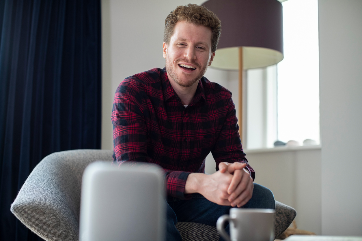 man in living room asks smart speaker a question
