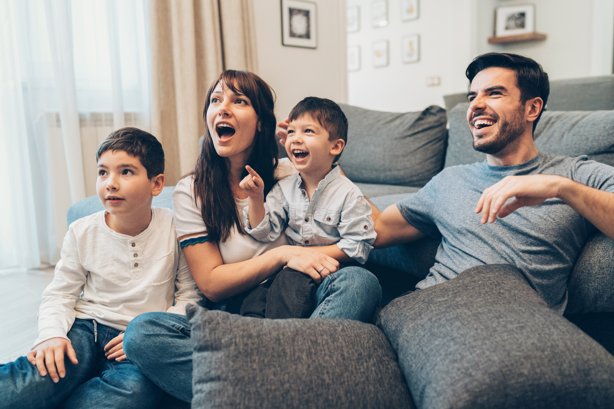 family relaxes at home watching movie together