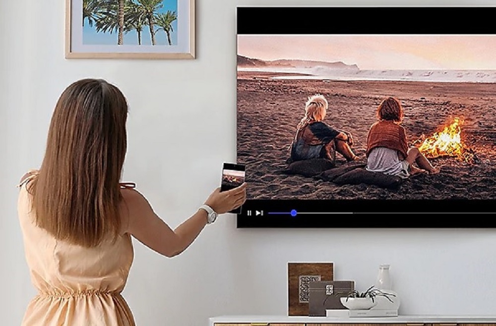 woman screenmirrors movie from smartphone to Samsung TU900 TV