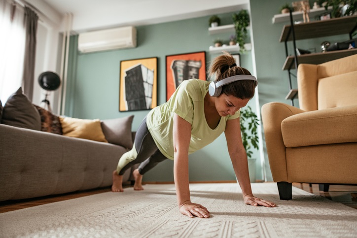 woman does a home workout wearing headphones 