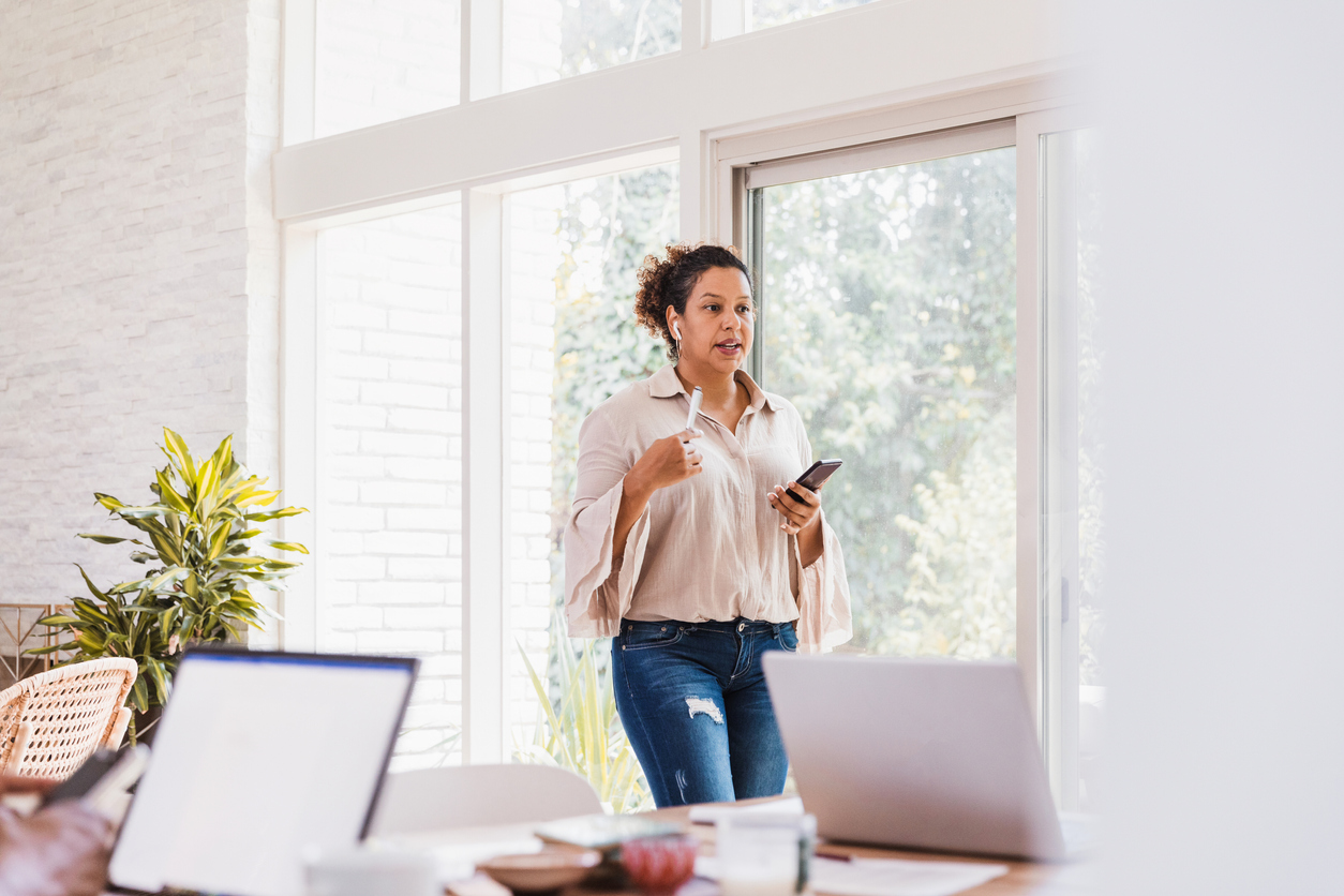Business woman paces while on a conference call in her home office
