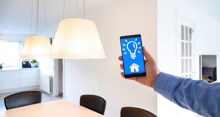 Hand holding a smart phone that controls the lighting.
