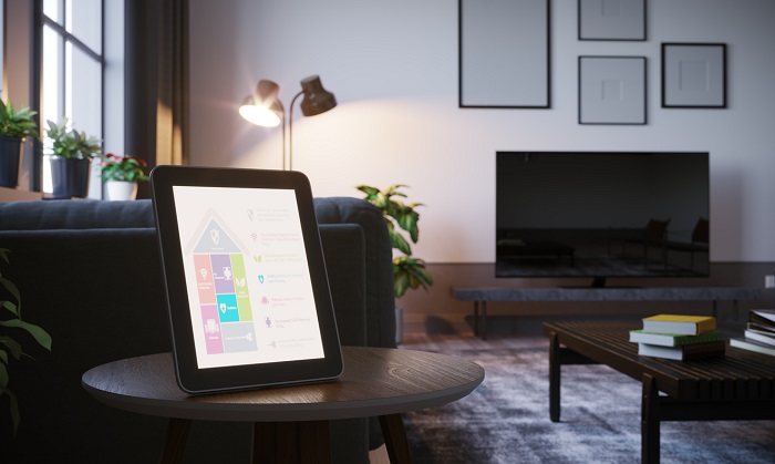 A modern living room with a tablet turned on and sitting on a table.