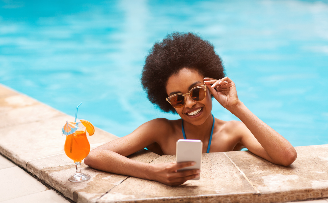woman lounging by the pool with her smartphone