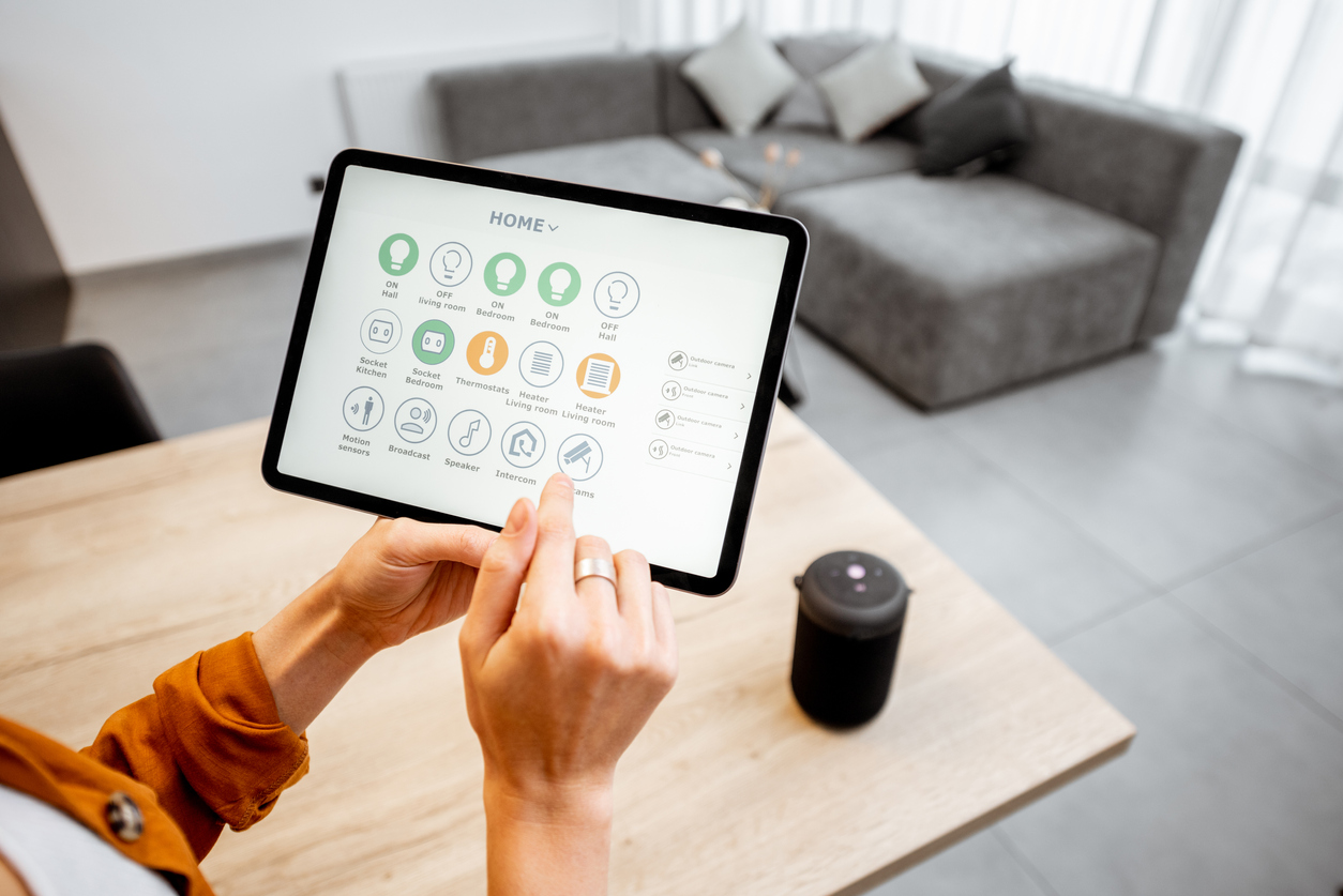 woman controlling home with a digital touch screen panel