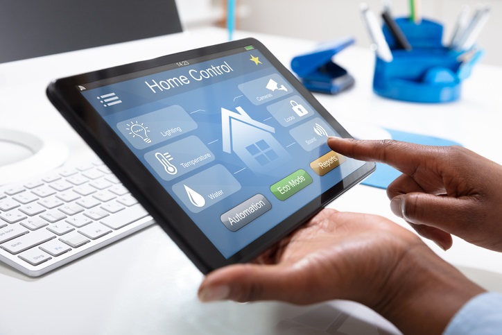 close-up of a person's hand using home control system on tablet
