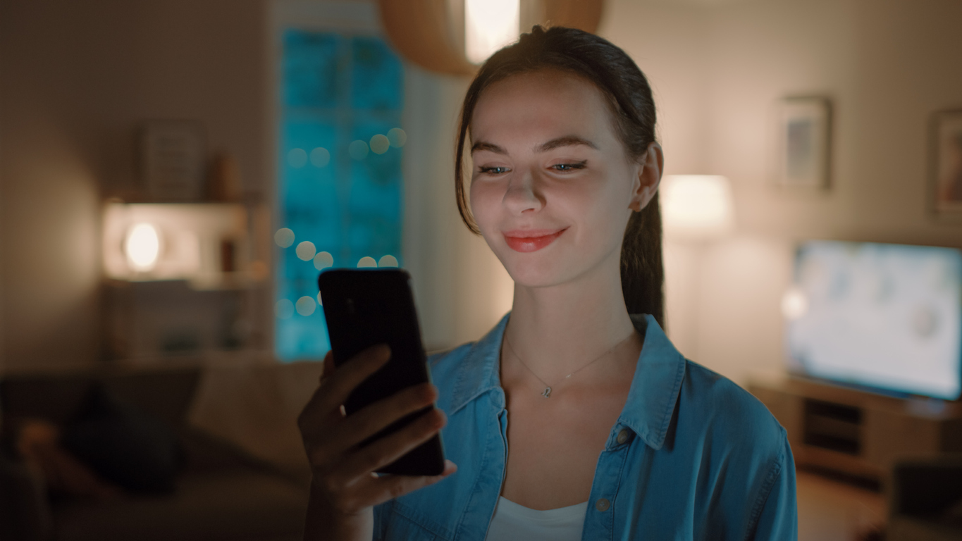 woman checks on smart home apps on her smartphone