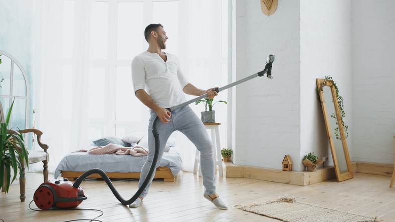 Man jams out as he vacuums because his music is following him from room to room