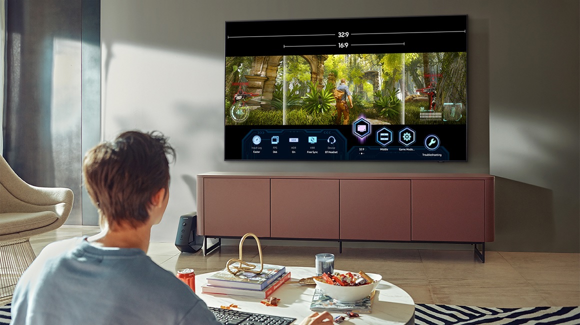 young man plays video game with Samsung Q80A TV in living room