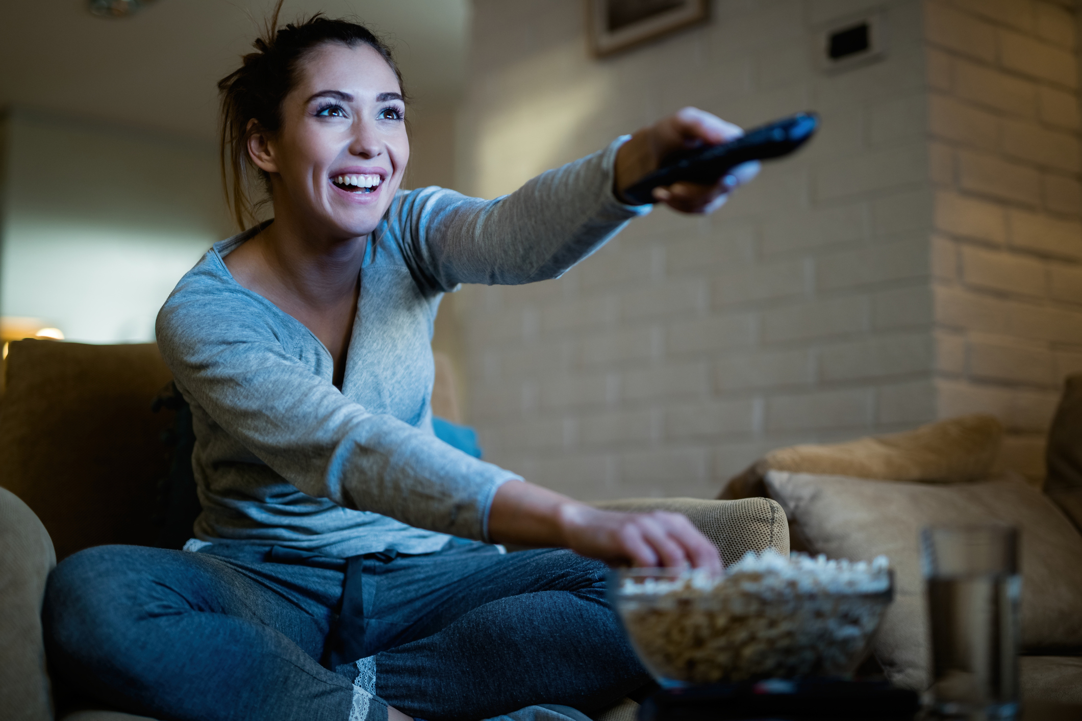 Drazen Zigic woman holding the remote looking for something to watch on TV