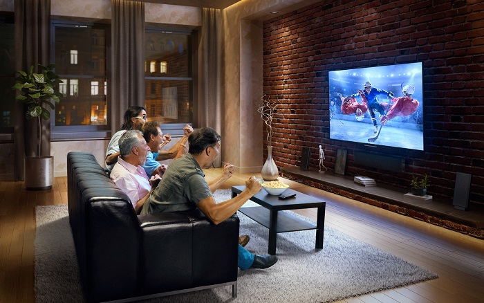 Group of guys watching TV together on a sofa.