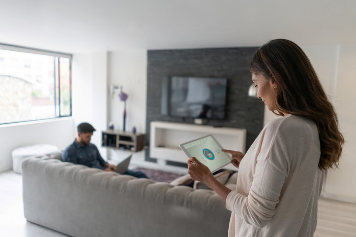 Woman living in an automated house and controlling the music from her tablet computer.