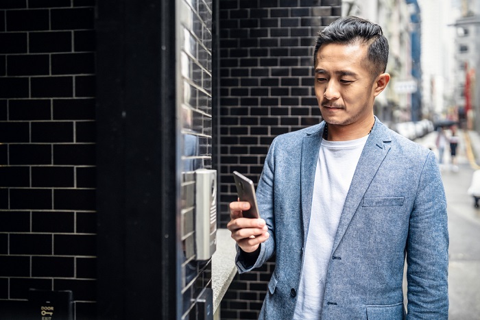 Man checks app on smart phone to enter building.