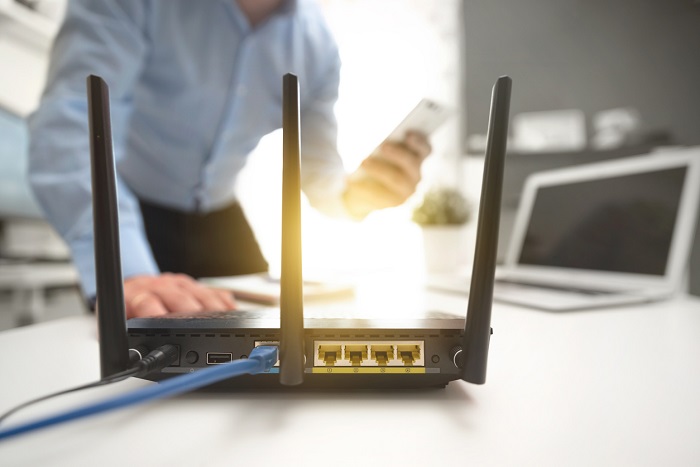 Wireless internet router with man working in the background.