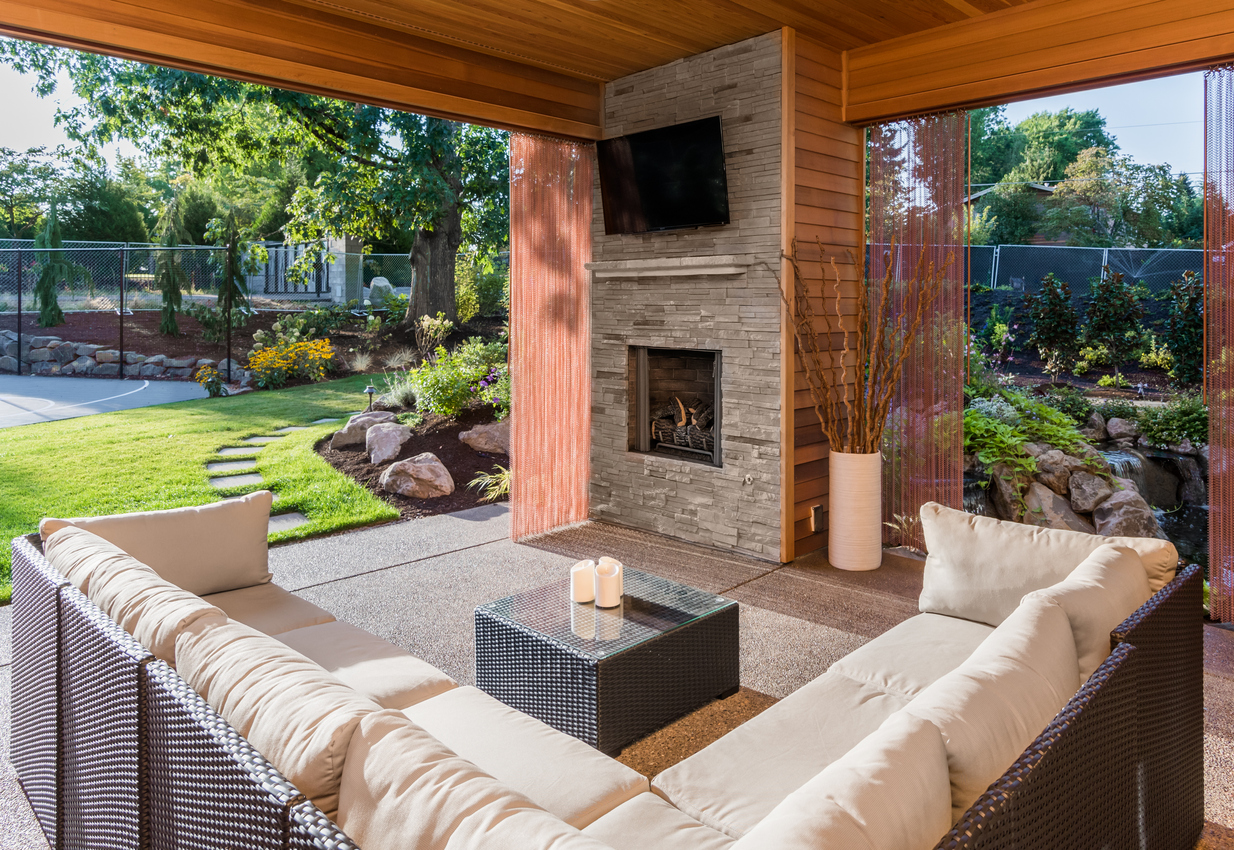 Covered patio with fireplace, TV, and couch