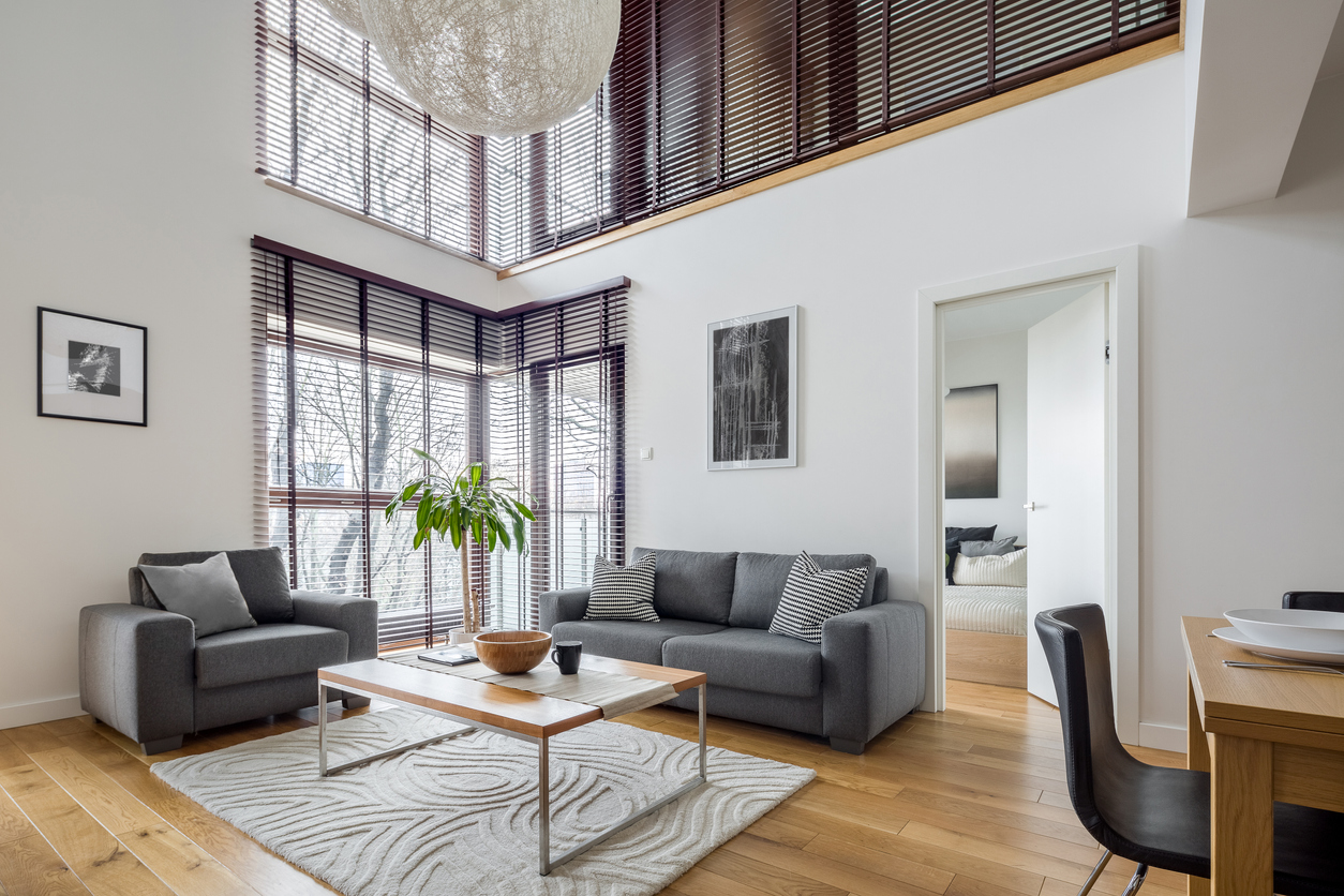 Living room with many, big windows with smart blinds and hardwood floor