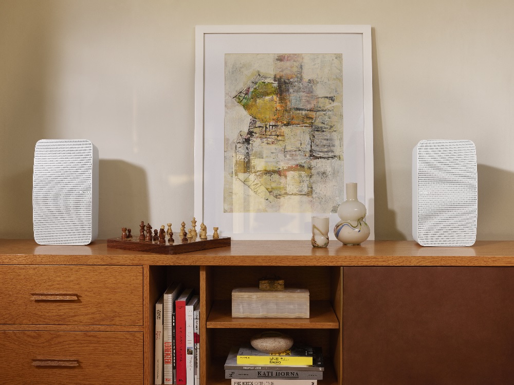 white Sonos Five bookshelf speakers flank desk accessories