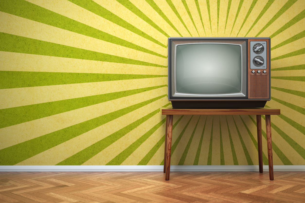 Retro tube TV set on a stand in front of a vintage background