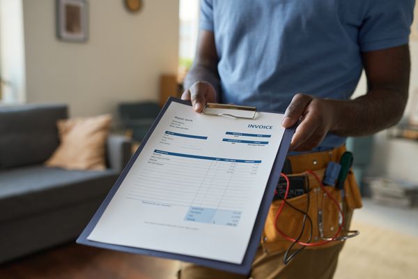 A person presenting an invoice on a clipboard 