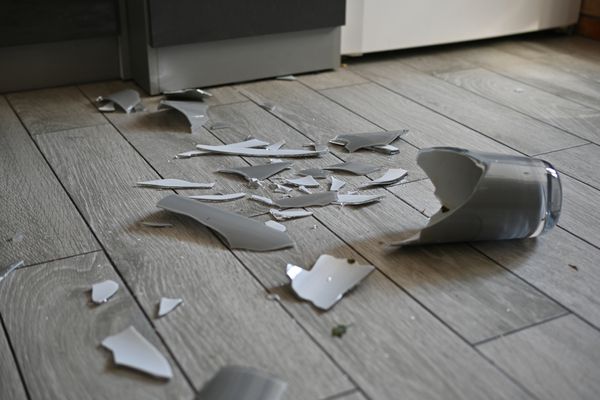 A shattered glass on wood flooring 