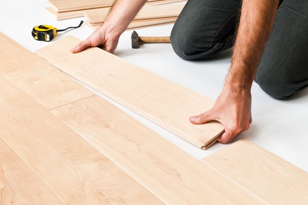 A person installing wood flooring 