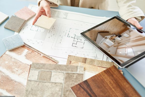 A person reviewing flooring blueprints with a tablet 