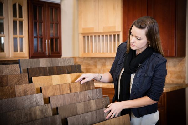 A woman inspecting hardwood flooring samples 