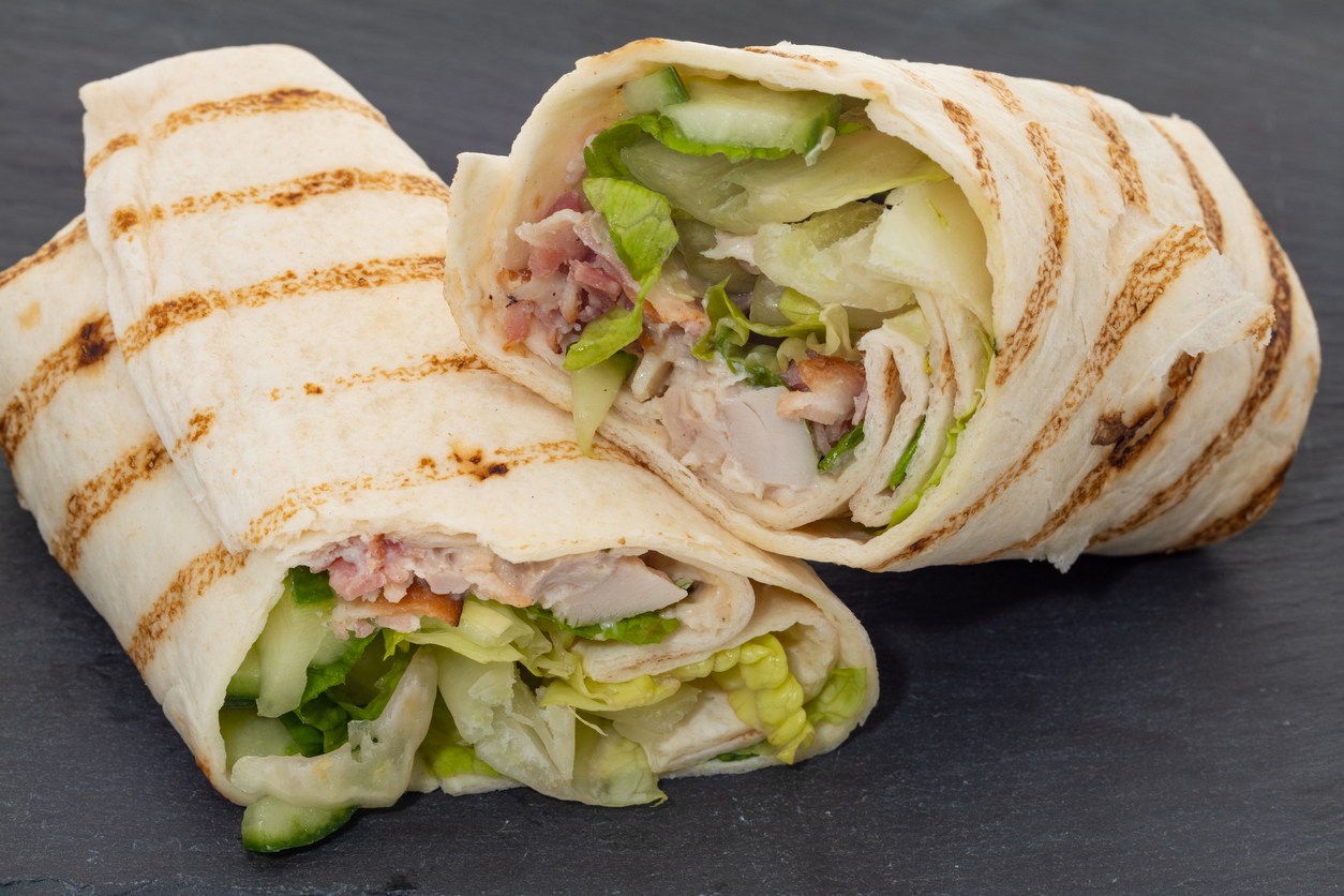chicken, bacon, and salad wrap  placed on a slate