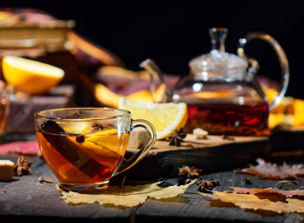 glass teacup of tea with cinnamon and tea with fall décor and teapot