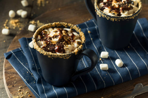 two hot chocolate filled mugs with graham cracker rims