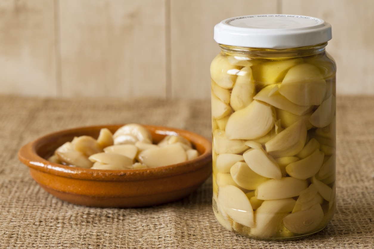 garlic confit in a shallow tapa bowl and inside an airtight glass jar