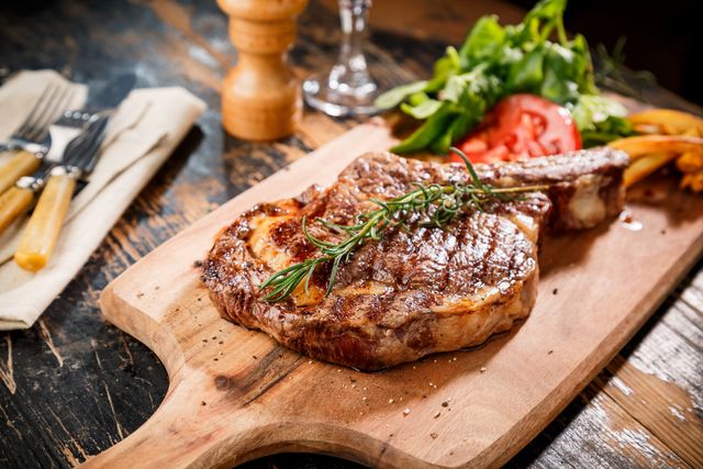 View of a perfectly cooked steak prepared and plated on a dinner table.
