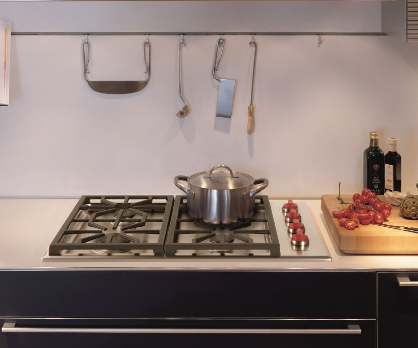 Gas cooktop with a pot atop it and a cutting board to its right
