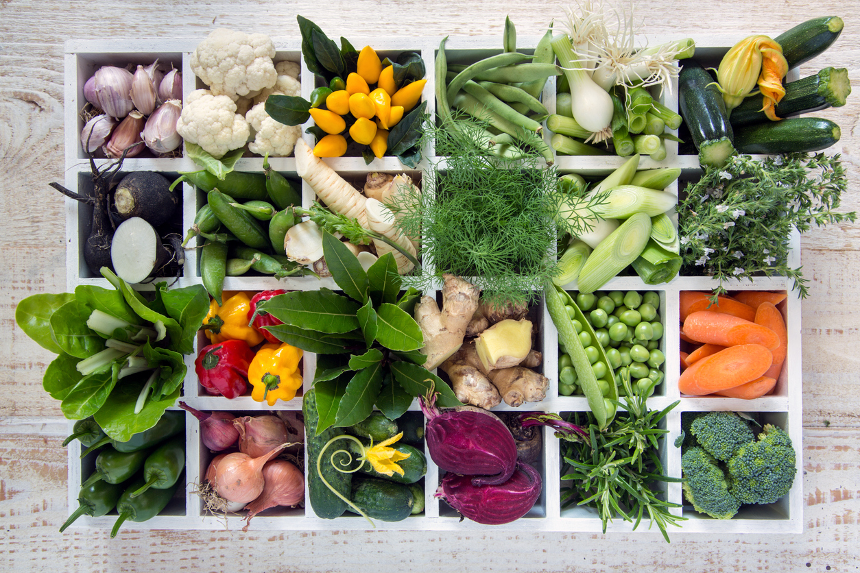 an assortment of vegetables arranged in a box of twenty-four cubbies