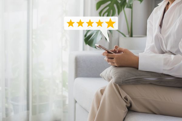 A woman sitting on a sofa with a graphic overlay with five golden stars