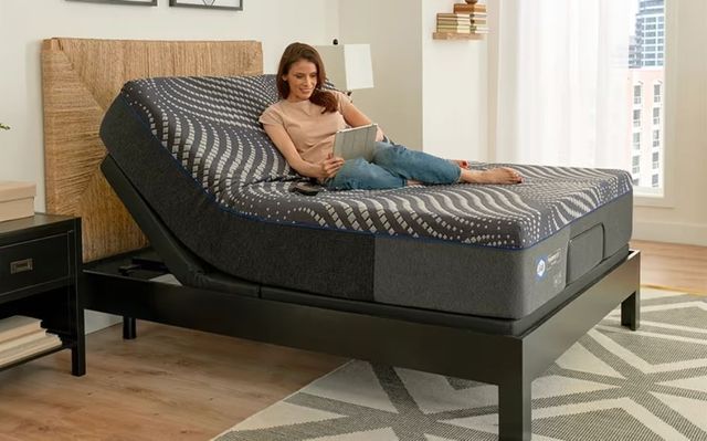 front view of a woman using an ipad on a mattress on an adjustable bed base