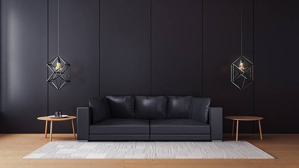 A wide view of a living room with black walls and a black sofa 