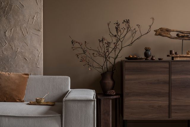 Front view of a boho rustic living room corner with a corduroy sofa and natural decor elements