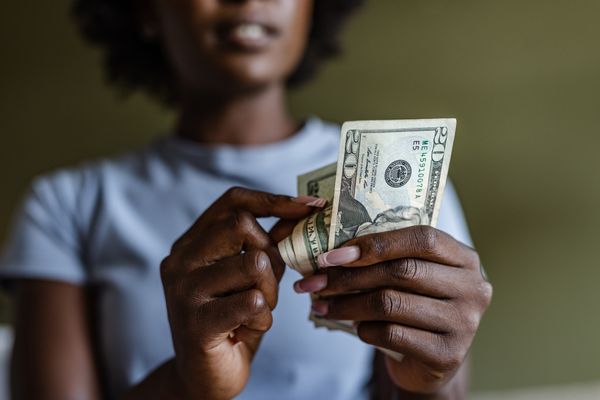 A person counting $20 bills