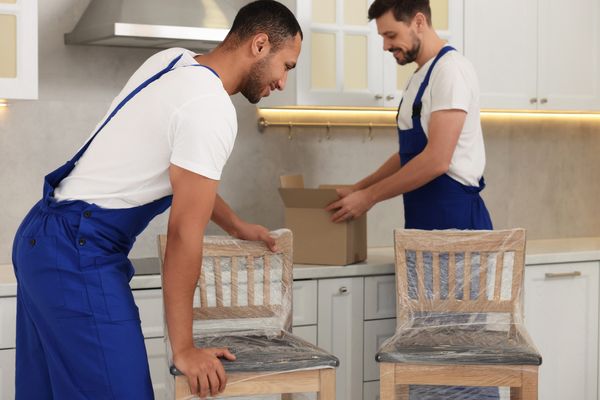 Two delivery men delivering dining room chairs 